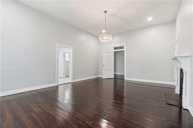 unfurnished living room featuring hardwood / wood-style flooring and an inviting chandelier