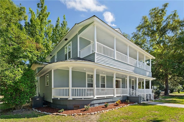 exterior space with central AC unit, a balcony, a porch, and a front yard