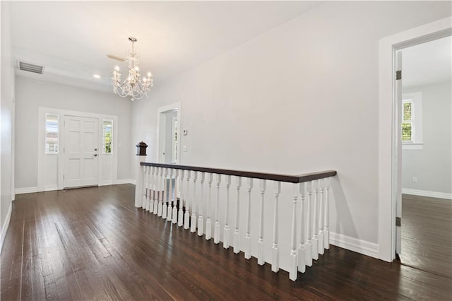 foyer entrance with a notable chandelier and dark hardwood / wood-style floors