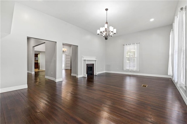 unfurnished living room with dark hardwood / wood-style floors and an inviting chandelier