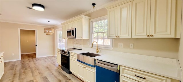 kitchen featuring appliances with stainless steel finishes, decorative light fixtures, ornamental molding, and sink