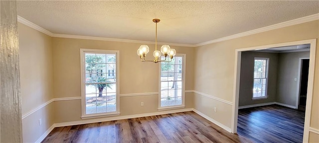 doorway featuring a notable chandelier, hardwood / wood-style floors, a textured ceiling, and ornamental molding