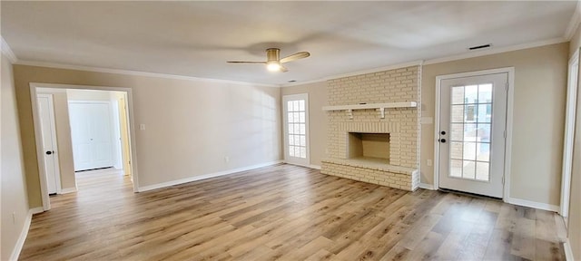 unfurnished living room with a fireplace, light hardwood / wood-style floors, ceiling fan, and a healthy amount of sunlight