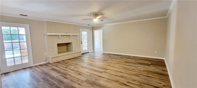 unfurnished living room featuring ceiling fan, a fireplace, wood-type flooring, and ornamental molding