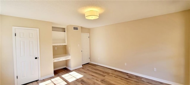 unfurnished bedroom with light hardwood / wood-style floors and a closet