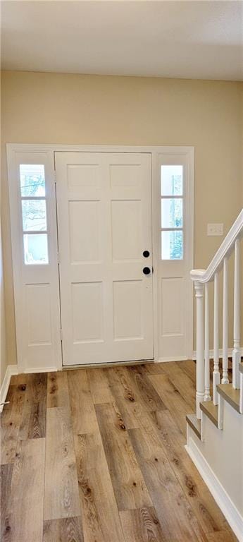 foyer with a wealth of natural light and light hardwood / wood-style flooring