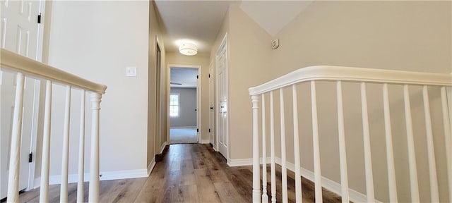 hallway with vaulted ceiling and light hardwood / wood-style flooring