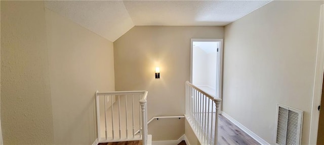 staircase featuring hardwood / wood-style floors and lofted ceiling