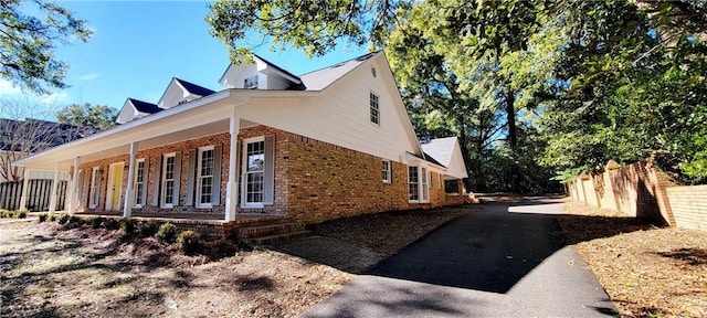 view of side of property featuring covered porch