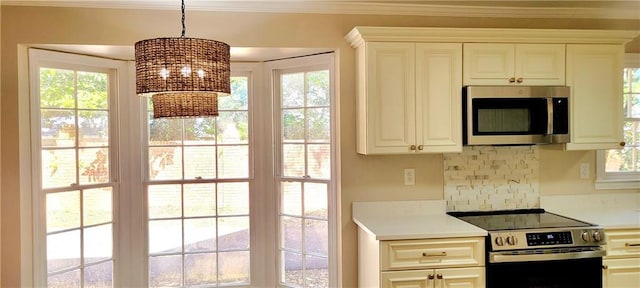 kitchen featuring pendant lighting, white cabinets, ornamental molding, and appliances with stainless steel finishes