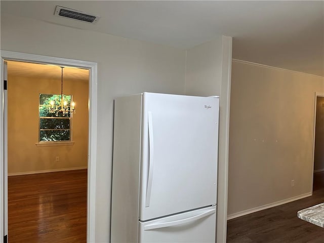 kitchen featuring white fridge, dark wood-type flooring, and a chandelier