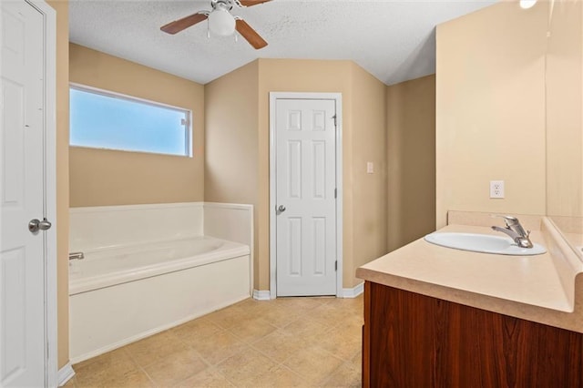 bathroom featuring vanity, a textured ceiling, a tub to relax in, and ceiling fan