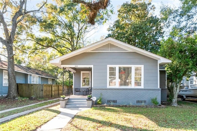 bungalow-style home with a front yard and covered porch