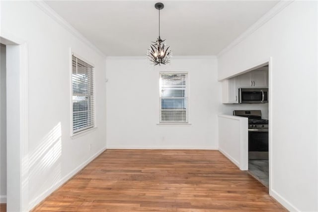 unfurnished dining area featuring an inviting chandelier, wood-type flooring, and ornamental molding