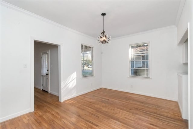 unfurnished dining area with a wealth of natural light, light hardwood / wood-style flooring, crown molding, and an inviting chandelier