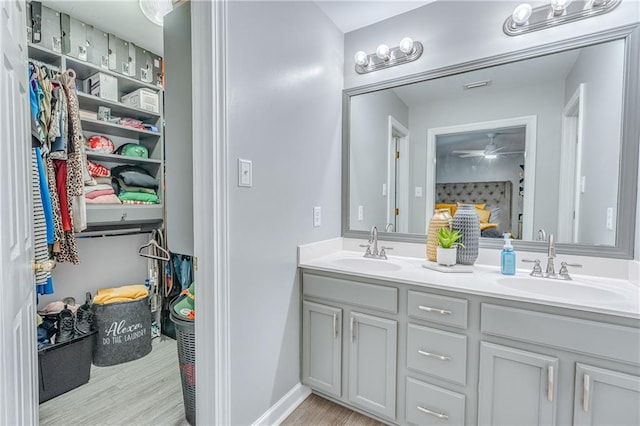 bathroom featuring ceiling fan, wood-type flooring, and vanity