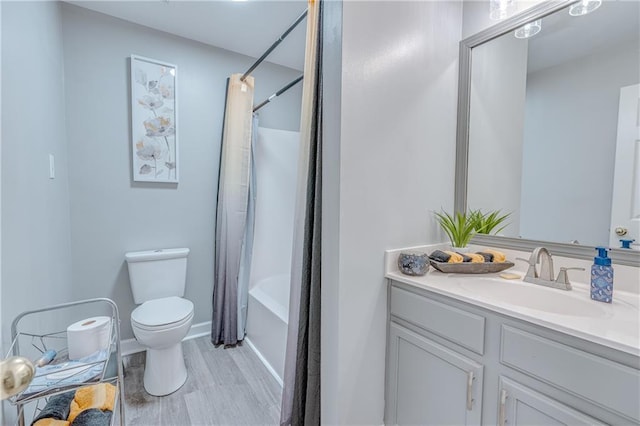 full bathroom with vanity, toilet, hardwood / wood-style floors, and shower / tub combo with curtain