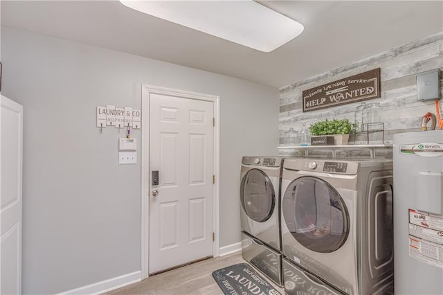 washroom with wood walls, light hardwood / wood-style flooring, separate washer and dryer, and water heater