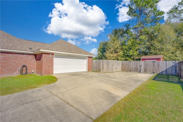 view of side of property featuring a garage and a yard