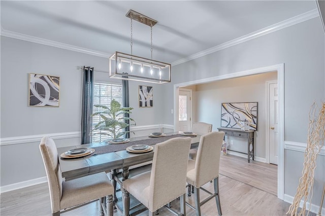 dining space with crown molding and light hardwood / wood-style floors