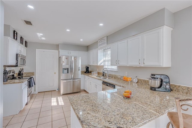 kitchen with white cabinets, stainless steel appliances, kitchen peninsula, and sink