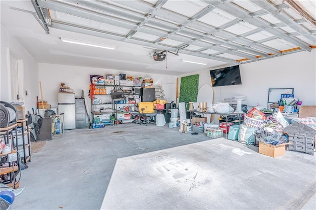 garage with a garage door opener and refrigerator