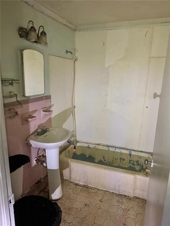 bathroom with crown molding, shower / bathing tub combination, and tile walls