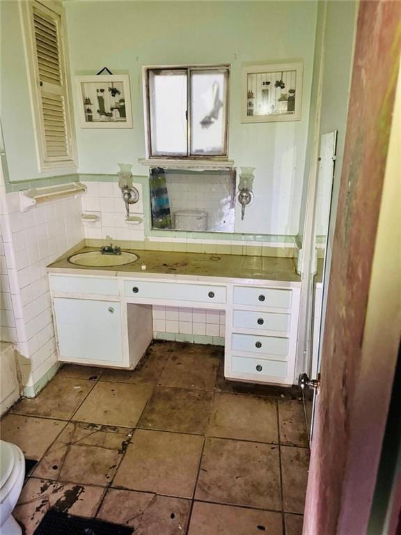 bathroom featuring vanity, tile walls, and toilet