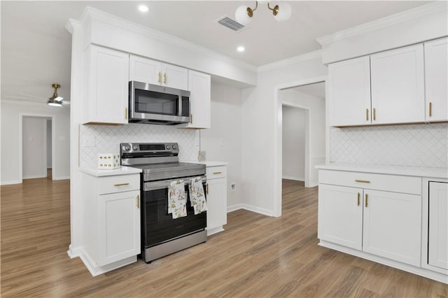 kitchen featuring light wood finished floors, visible vents, stainless steel appliances, light countertops, and white cabinetry