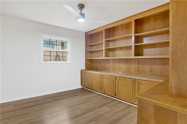 spare room with ceiling fan, light wood finished floors, and baseboards