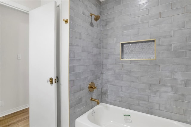 full bath with bathing tub / shower combination, baseboards, and wood finished floors