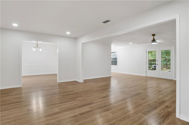 empty room featuring a healthy amount of sunlight, visible vents, wood finished floors, and recessed lighting