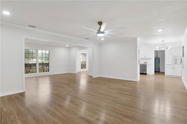 unfurnished living room featuring ornamental molding, ceiling fan with notable chandelier, and wood finished floors