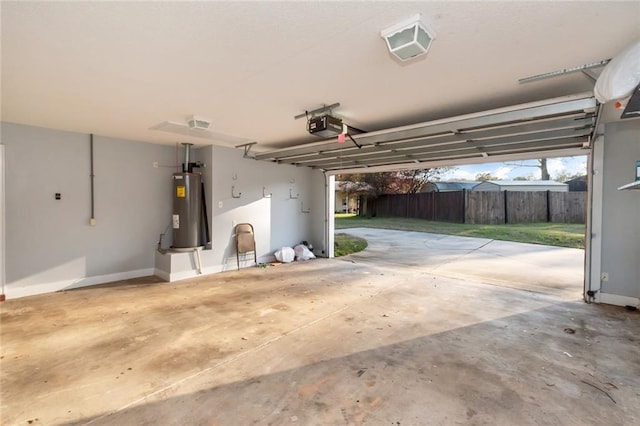 garage featuring baseboards, a garage door opener, and electric water heater