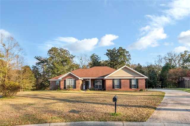 single story home featuring concrete driveway, a front lawn, and brick siding