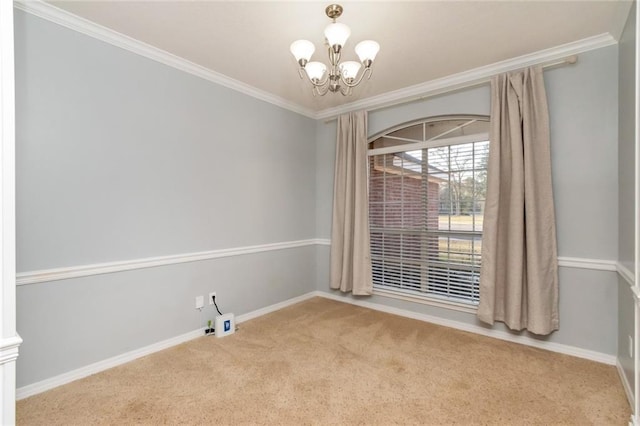 carpeted empty room with baseboards, ornamental molding, and a notable chandelier