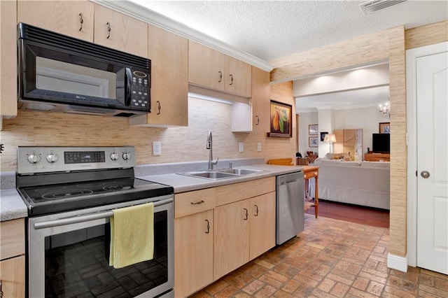 kitchen featuring visible vents, light brown cabinetry, light countertops, appliances with stainless steel finishes, and a sink