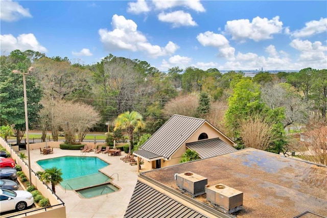 pool featuring a community hot tub and a patio area