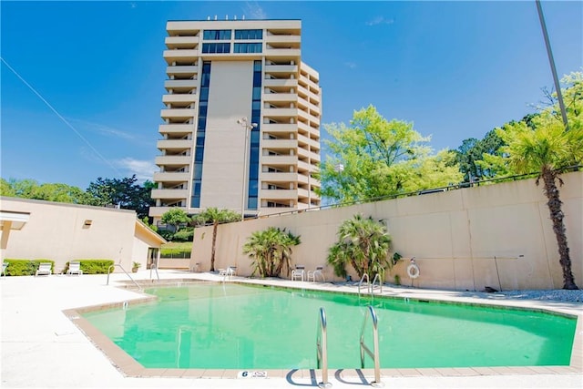 community pool featuring a patio area and fence