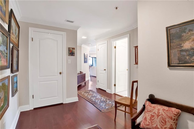 interior space featuring visible vents, baseboards, dark wood finished floors, and crown molding