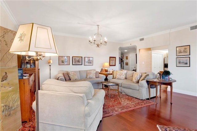 living room featuring visible vents, an inviting chandelier, wood finished floors, and crown molding