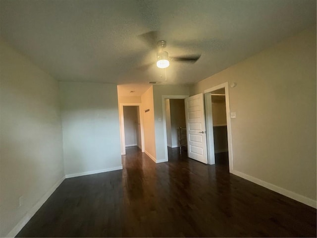 spare room featuring a textured ceiling, ceiling fan, and dark hardwood / wood-style flooring