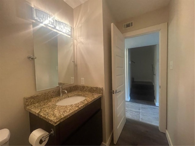 bathroom featuring vanity, toilet, and hardwood / wood-style flooring