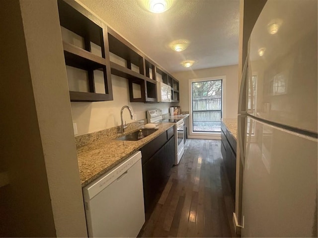 kitchen with white appliances, light stone counters, dark hardwood / wood-style floors, and sink