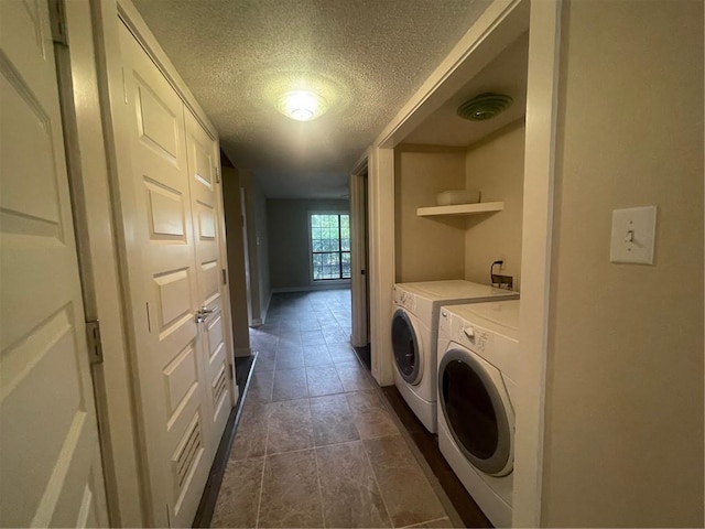 laundry area with a textured ceiling and washing machine and dryer