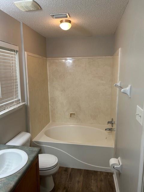 6611 Morgan Jackson Ct, Mobile, AL 36582 - full bathroom featuring wood finished floors, toilet, vanity, a textured ceiling, and tub / shower combination
