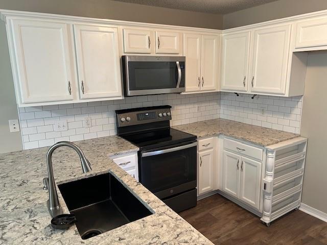 6611 Morgan Jackson Ct, Mobile, AL 36582 - kitchen featuring stainless steel microwave, electric stove, a sink, and white cabinets
