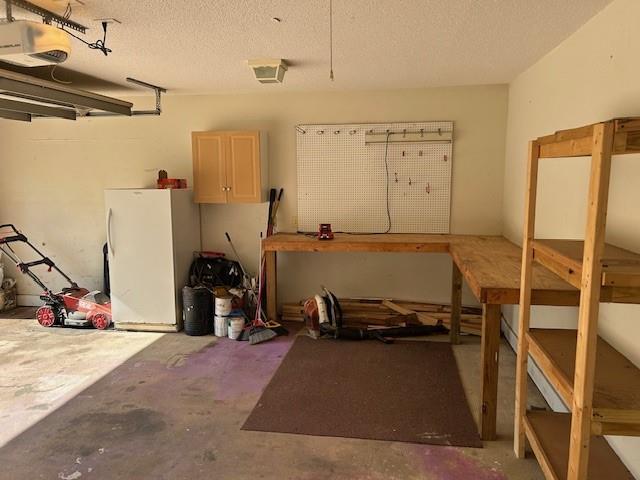 6611 Morgan Jackson Ct, Mobile, AL 36582 - garage featuring freestanding refrigerator, a workshop area, and a garage door opener