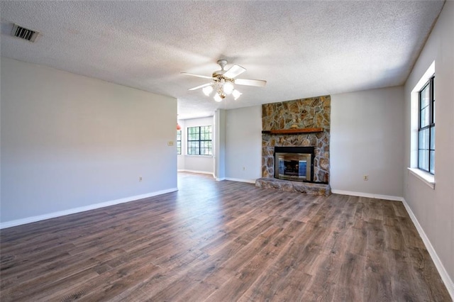17180 Jim Platt Rd, Citronelle, AL 36522 - unfurnished living room featuring ceiling fan, dark wood finished floors, a textured ceiling, baseboards, and a fireplace