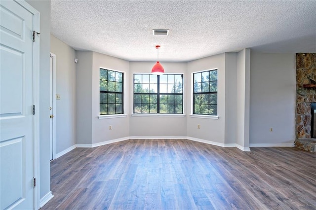 17180 Jim Platt Rd, Citronelle, AL 36522 - unfurnished dining area with a textured ceiling, plenty of natural light, dark wood finished floors, a fireplace, and baseboards